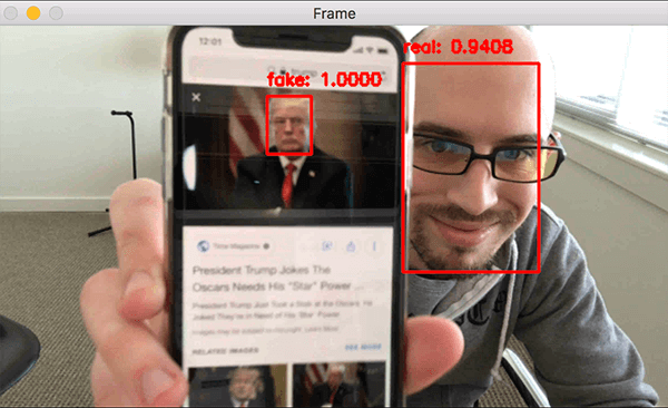 Liveness detection example showing two faces: photo on the phone marked as fake and a person holding the phone marked as real