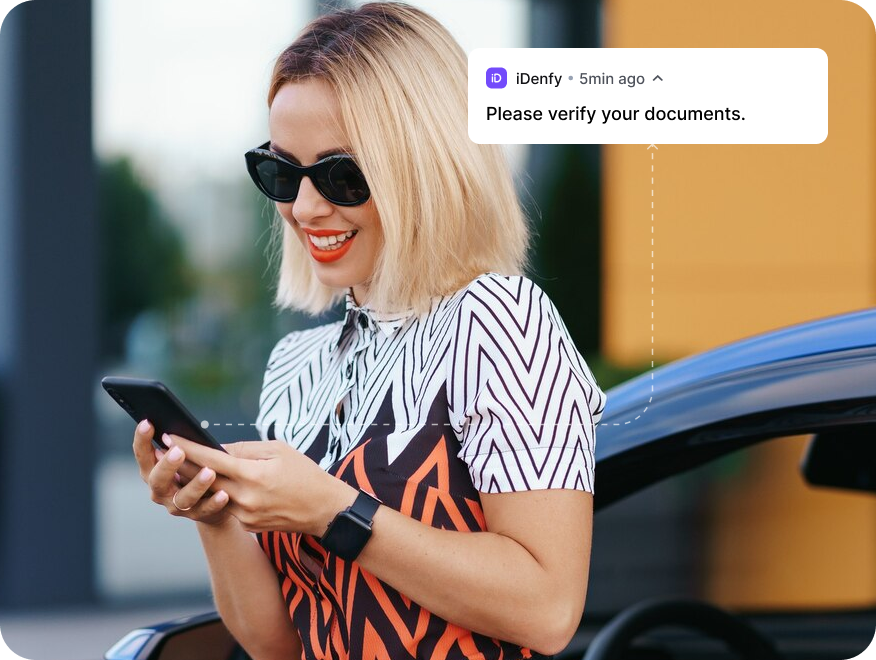 A woman getting a "Please verify your documents." notification on her phone.